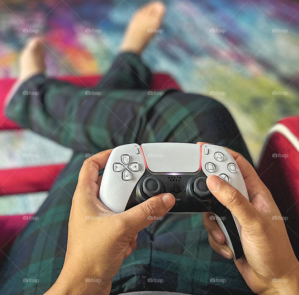 Gamer’s view, playing video games, woman holding PlayStation 5 controller, gaming on a PS5 console, playing games on a PlayStation 