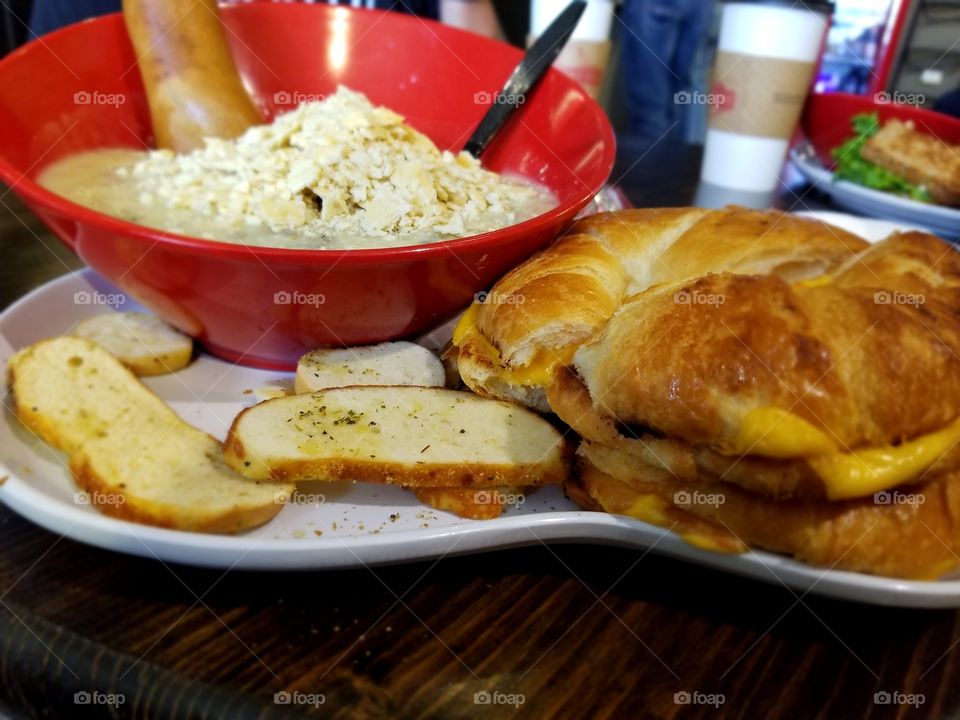 bagel with cheese and chicken and wild rice soup with crackers and bagel chips