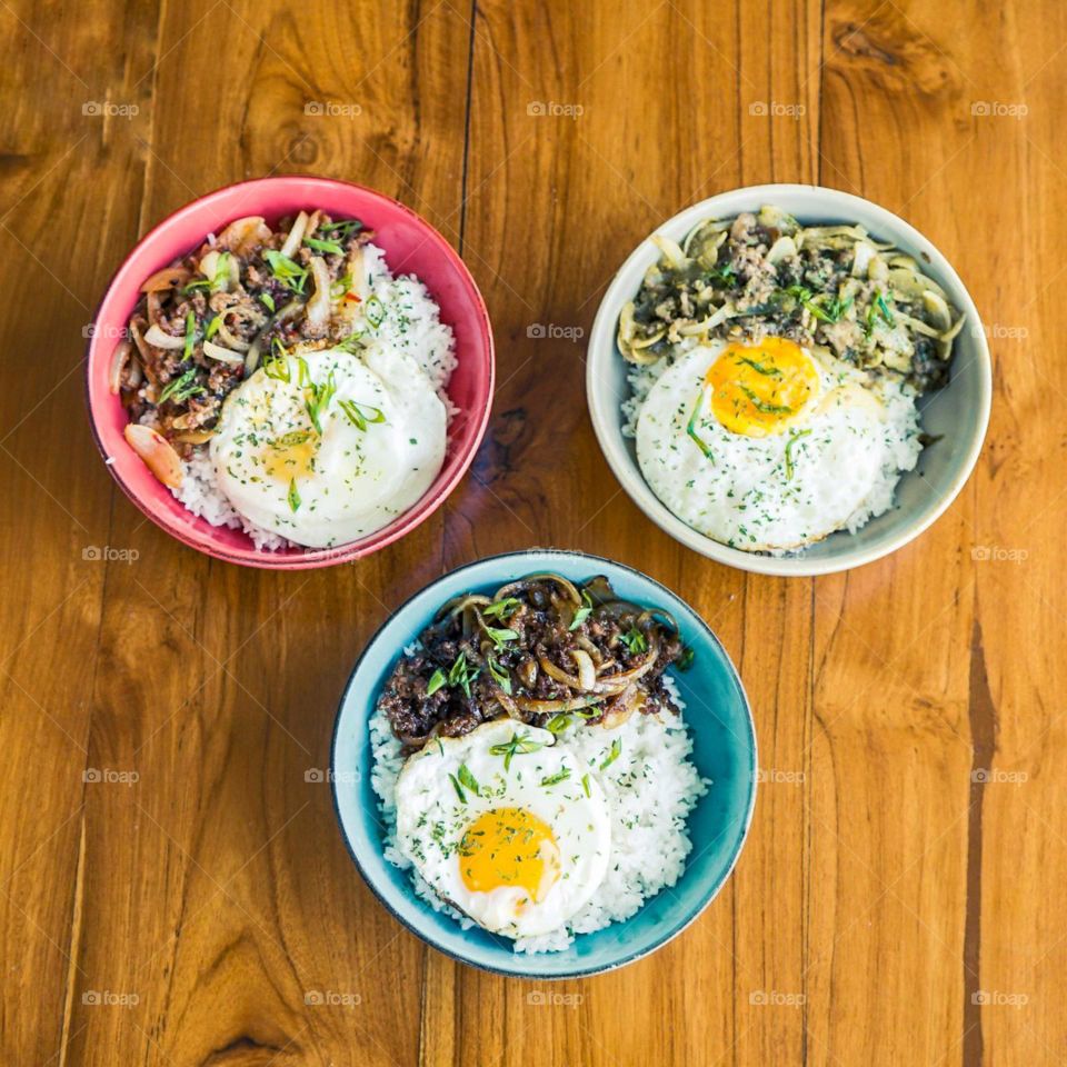 Three heavy food bowls in the photo from above. Bowl. Circle. Table. Wood. Wood pattern. Egg. Rice. Café. Restaurant. Food. Eat. Sunny side up. Chicken. Chicken eggs. Texture. Photography. Aesthetic.