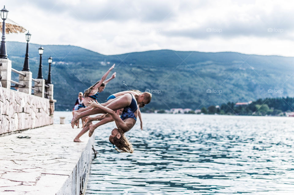 kids are jumping off dock