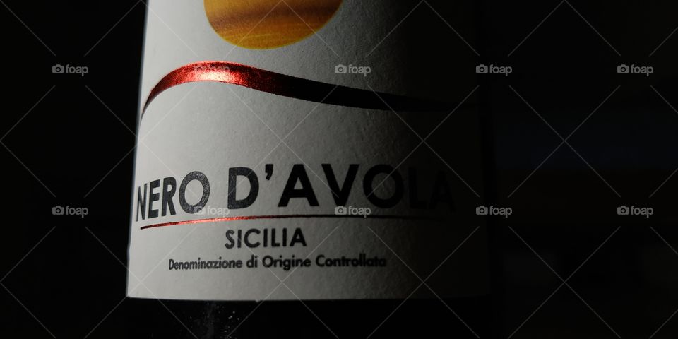 An experiment in the use of light and depth of field on a curved surface. This is a detail of a photo, shows a bottle of Sicilian wine "Nero d'Avola". This photo is taken with a smartphone.