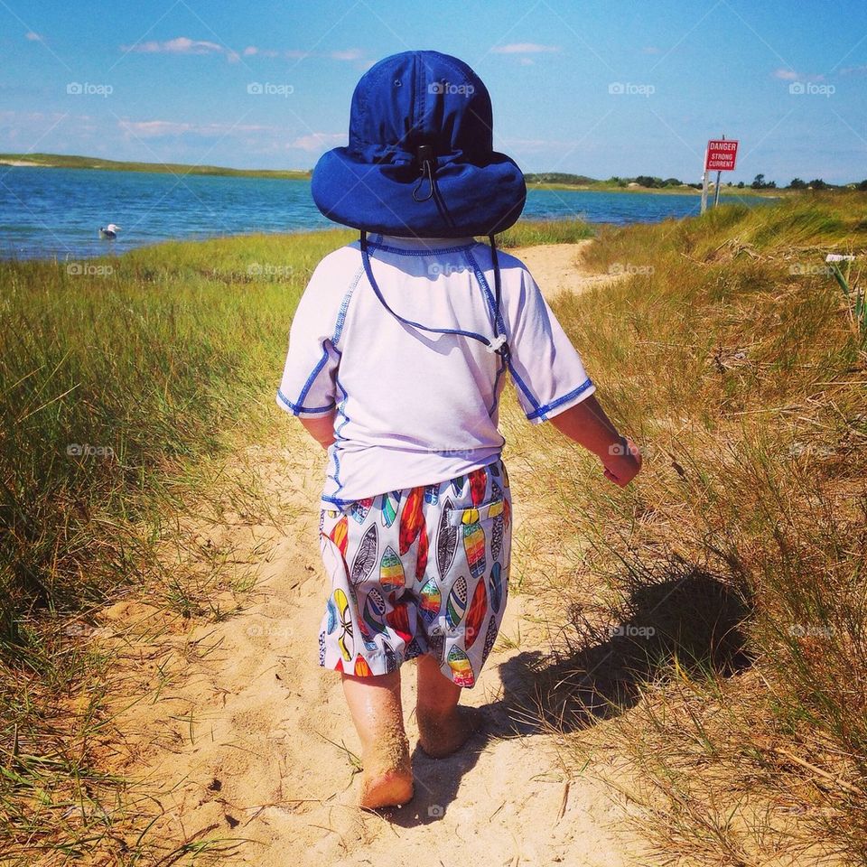 Rear view of a child walking at beach