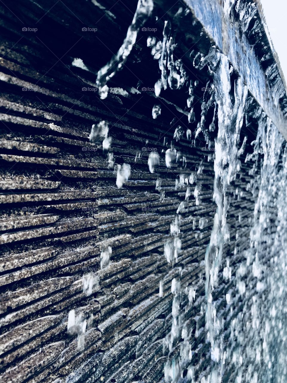 Waterdrops falling down a stony wall