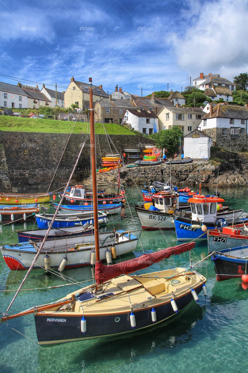 Cornish Fishing Village. A busy Cornish harbour full of fishing boats on a sunny summer's day. Blue sky and wispy clouds.