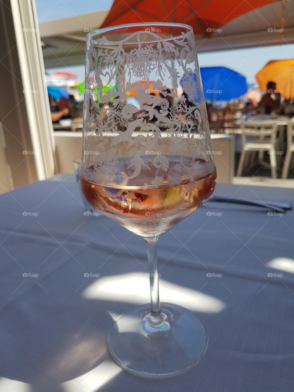 Glass of rosé wine at the beach bar in a sunny day of vacation