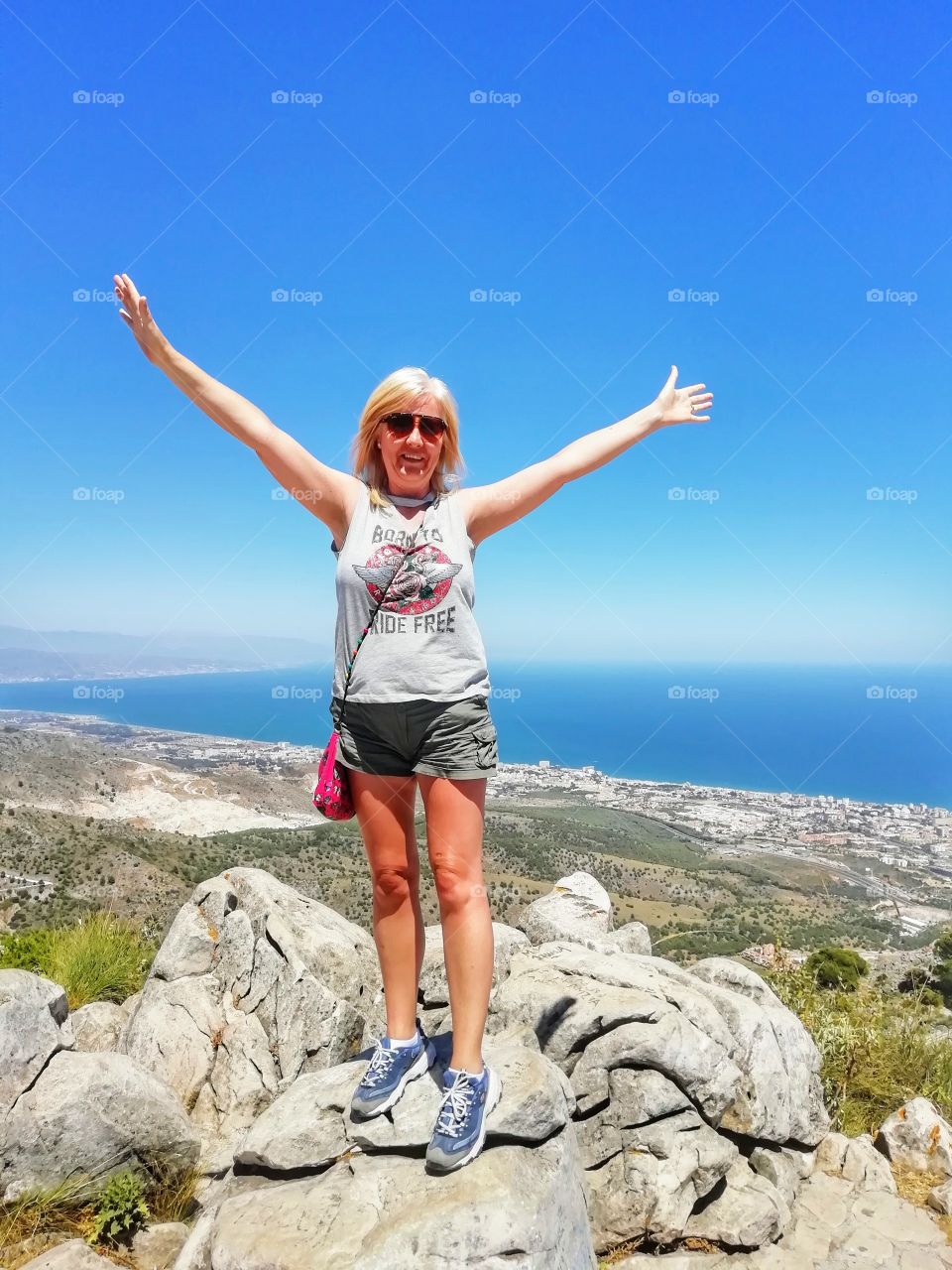 beautiful blonde female in shorts and t shirt standing on rocks over looking
Benalmádena spain