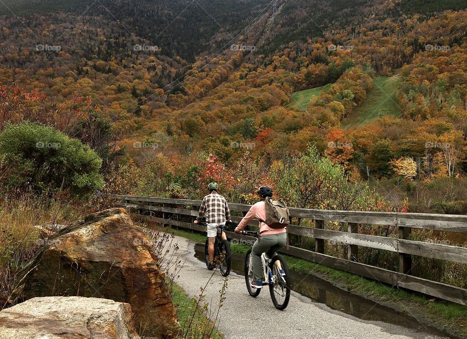 Two people riding bikes in the mountains. Fall season in New Hampshire. 