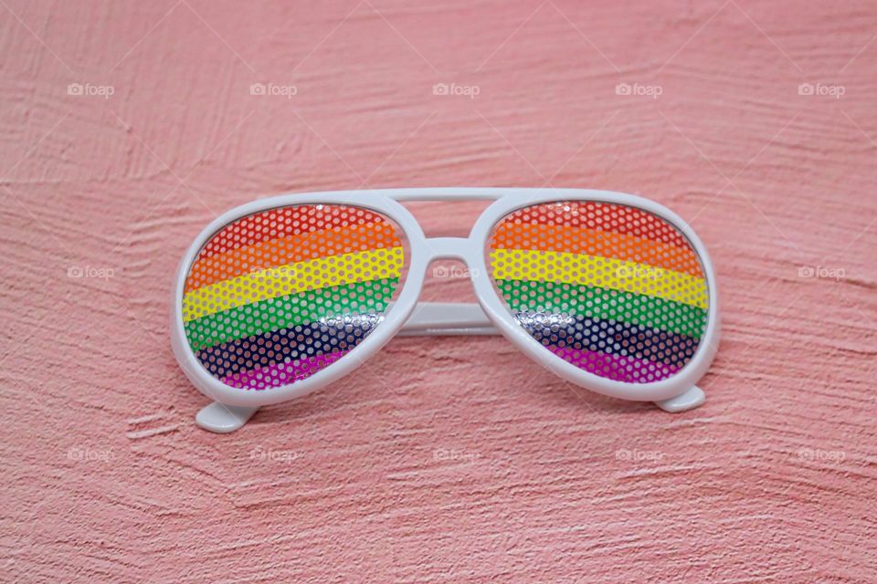 Rainbow glasses on pink background
