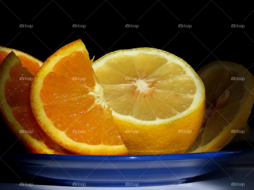 Orange and lemon on a blue plate