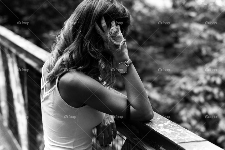 Rear view of young woman standing near fence