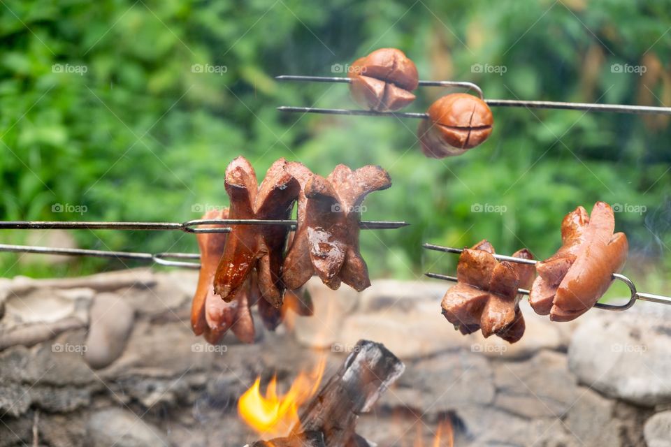cooking the sausages and meat over the fire