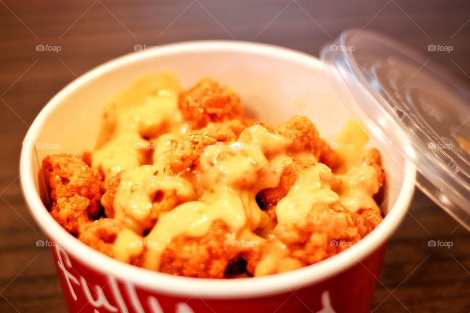 New fried chicken  Put in a paper cup to help reduce global warming and topped with cheese. Looks delicious.