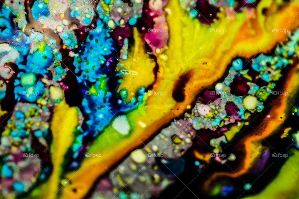 The ink to refill the printer cartridge was spilled onto the white washbasin and the paints blended into abstract drips and patterns.