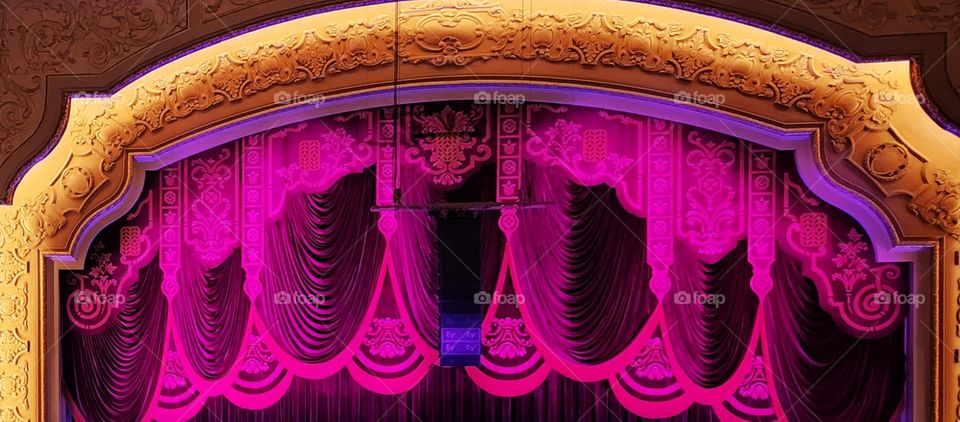 Admiring the bold colorful theater decor as the curtain is about to go up for a stage performance