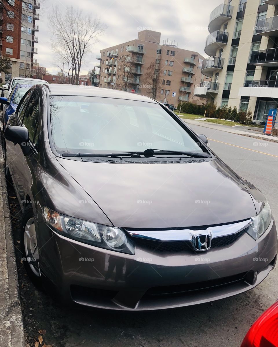 This is a grey 2010 Honda Civic parked on the street in Montreal. Cars.