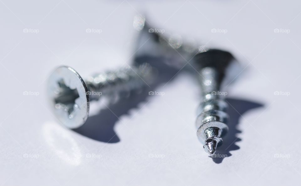 Closeup macro of metal screws on white background 