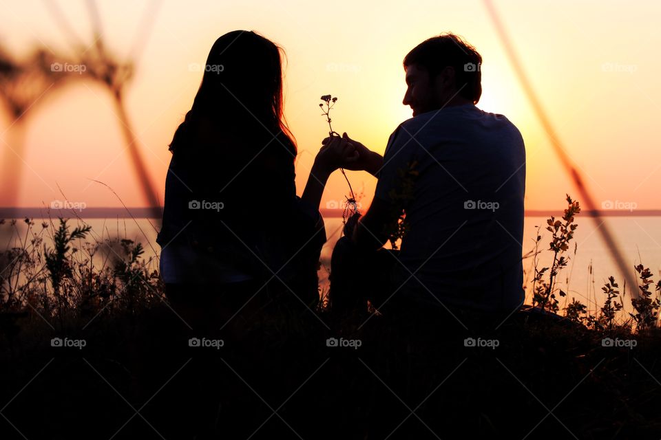 Silhouette of man and woman on the sunset 