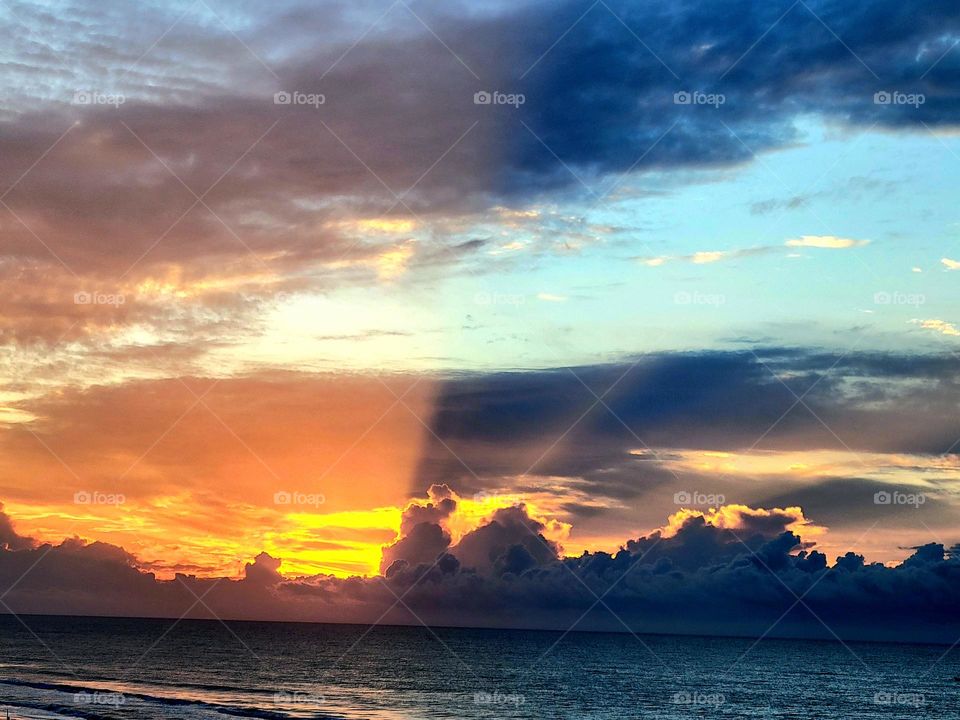 A view of the beach with a glorious sunrise
