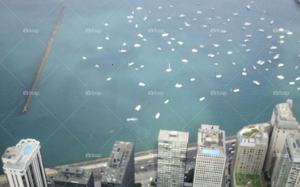 An aerial view of city buildings along the shore of Lake Michigan with several boat spotting the water 