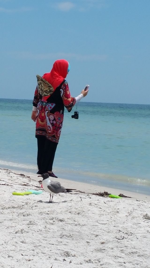 Multi Tasking on the beach. people watching at the beach