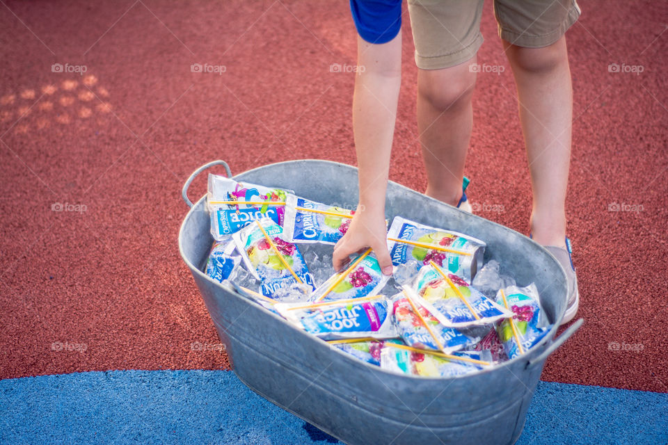 Bucket of Capri Sun Juice Pouches on Ice with Child Reaching for One