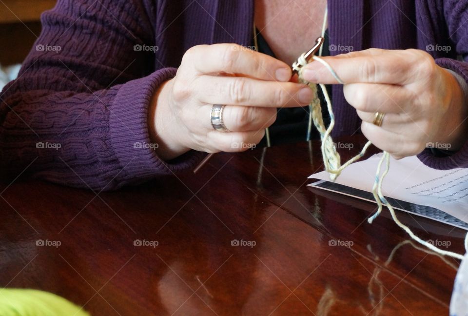 Woman's hands working with needle and yarn