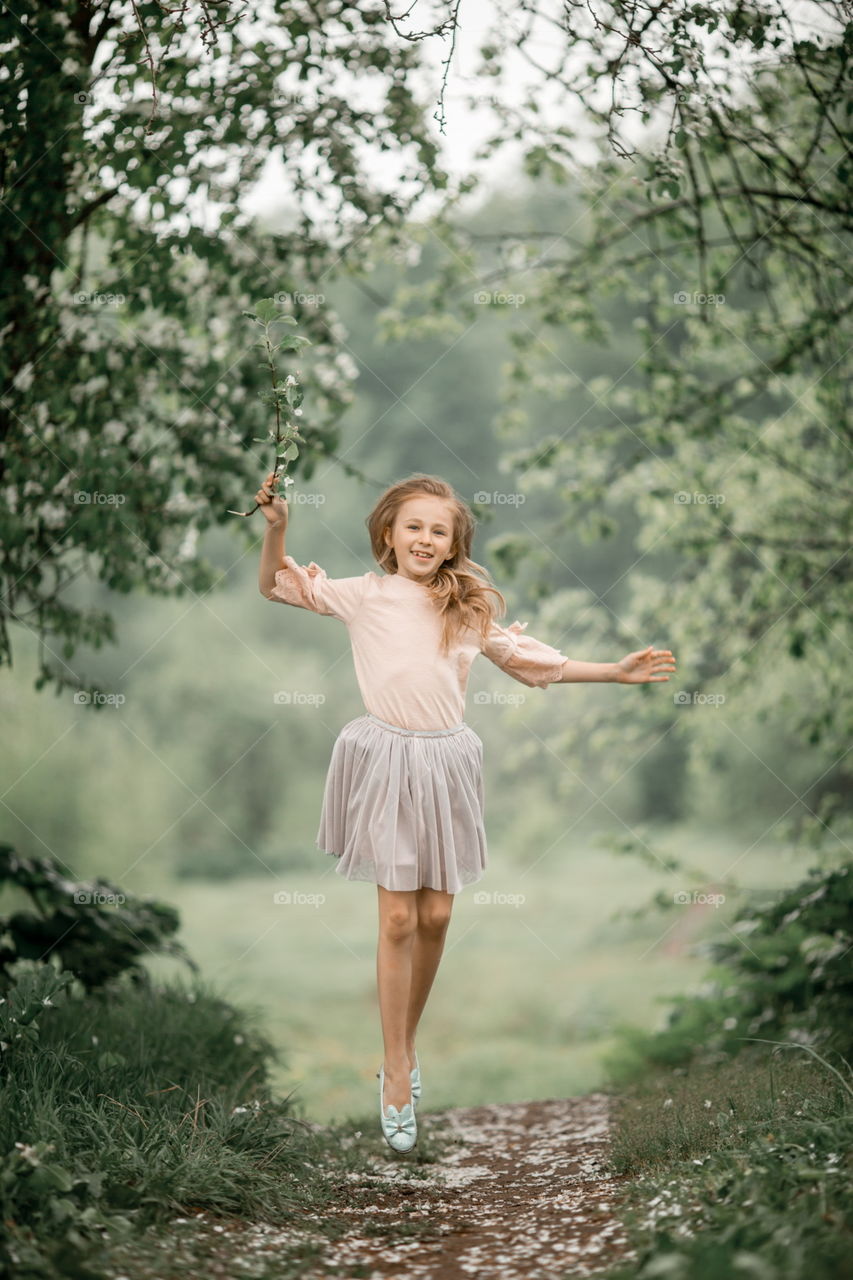 Girl in blossom garden at rainy day