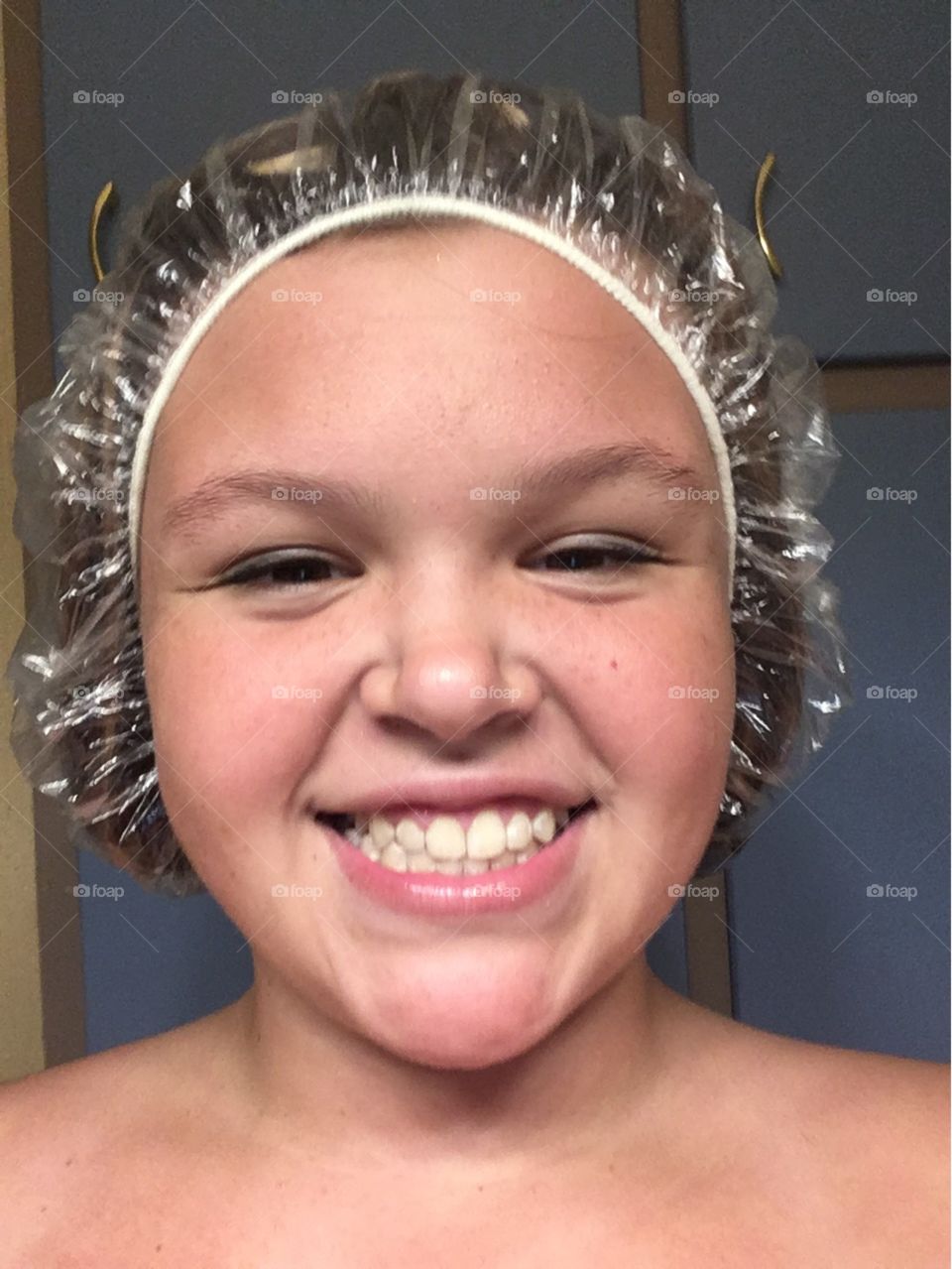 Teenage girl wearing plastic shower cap
