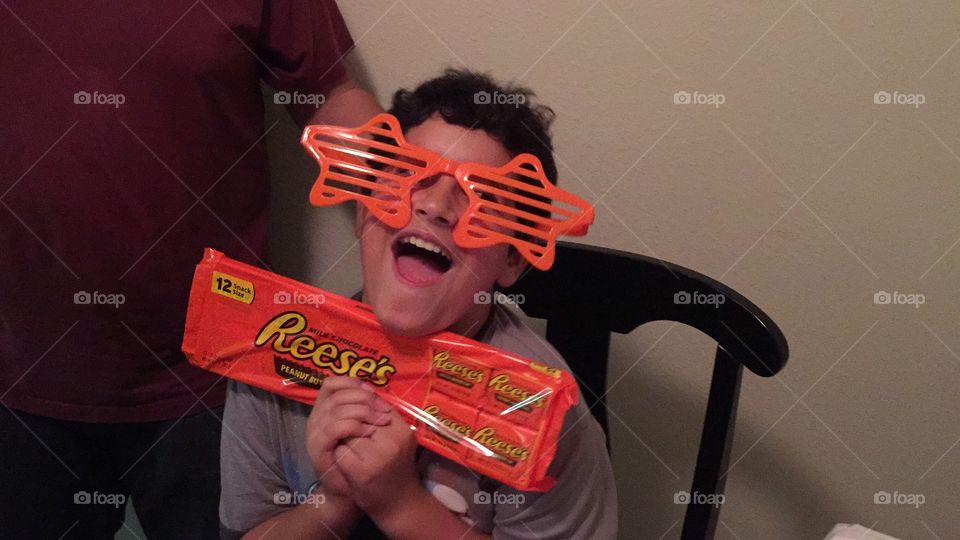 Goofing around. Boy posing with candy and silly glasses.