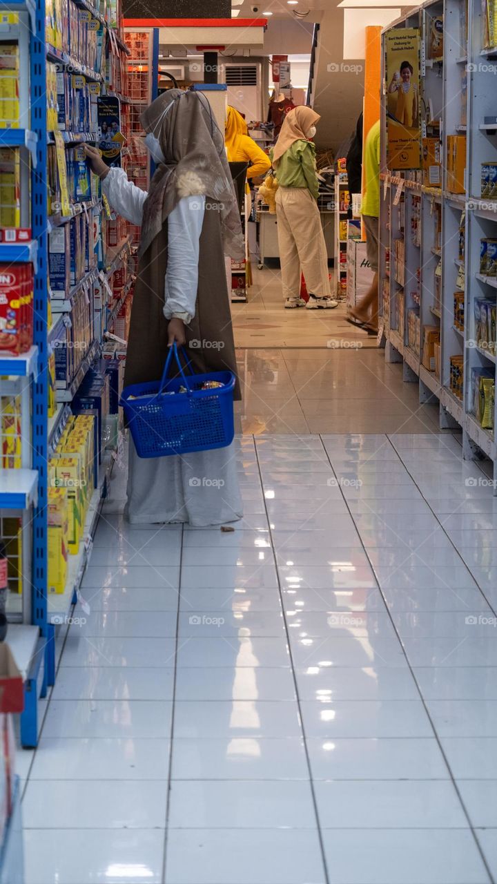 shopping at the supermarket with a blue basket