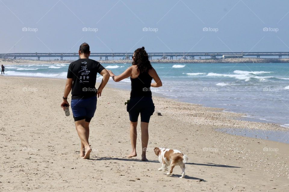 Man and woman walking with a dog