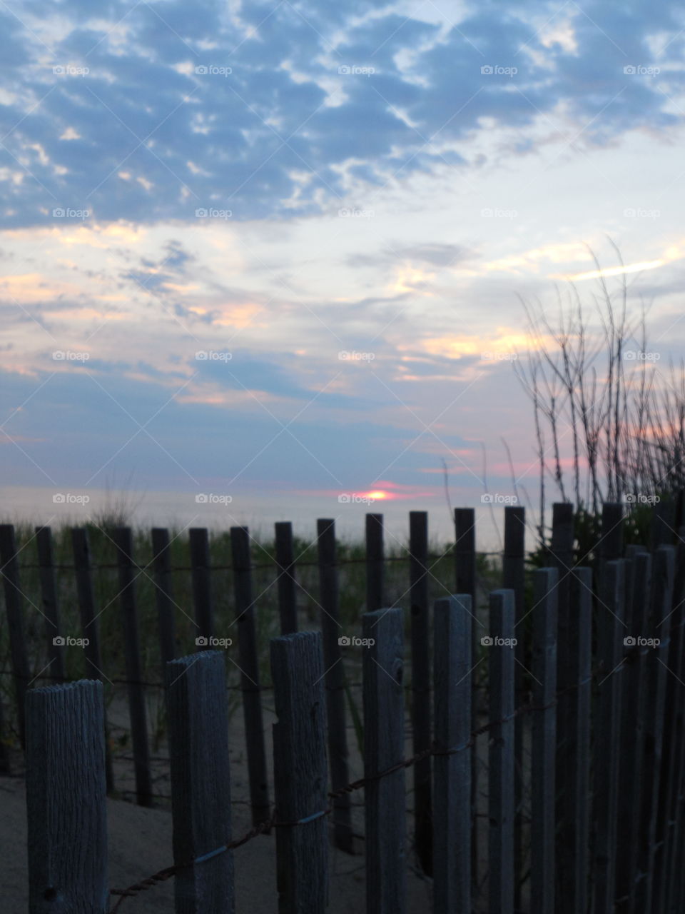 Sunrise over Dewey Beach Delaware dunes grass and fence