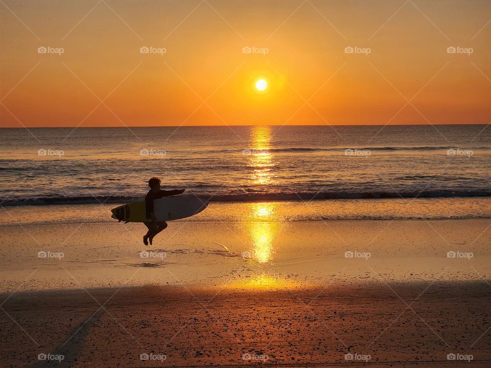 Happy surfer girl. Jumping with surf board