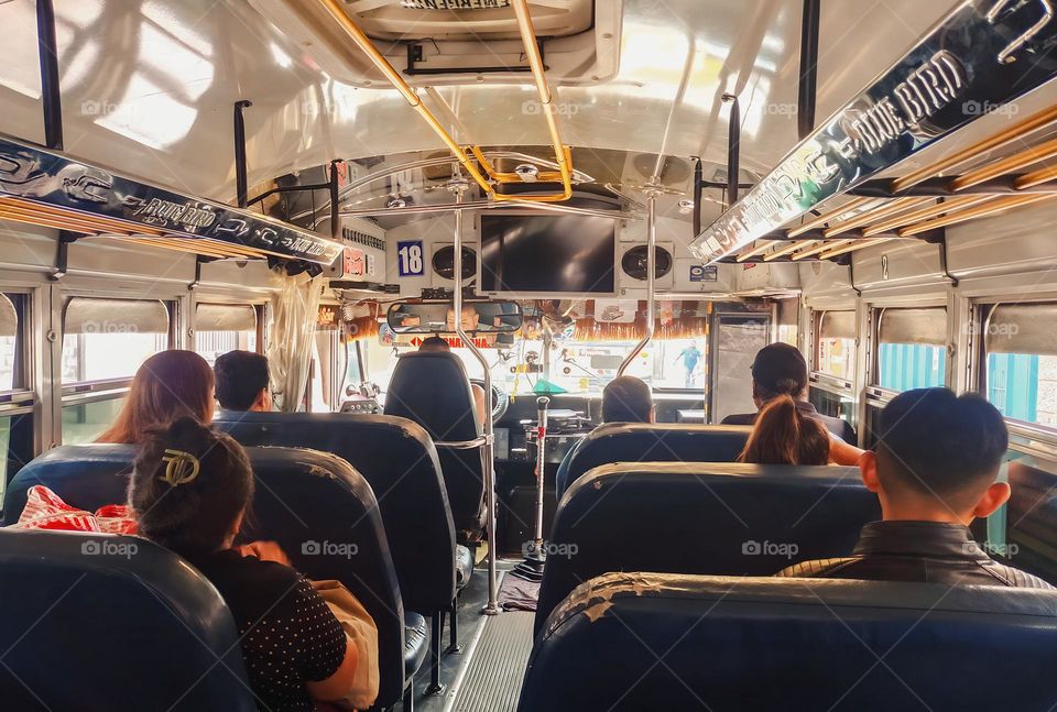 The interior of a colorful public transport, called a chicken bus, from Guatemala, with several passengers