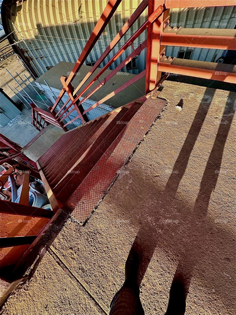 This is the red metal staircase of the „Pulaski Bridge“ at „Newtown Creek“ in LIC, Queens. The setting sun illuminates the structures and casts shadows over them that recombine with the shapes to form eclectic patterns. 2024. Hypnotic Productions