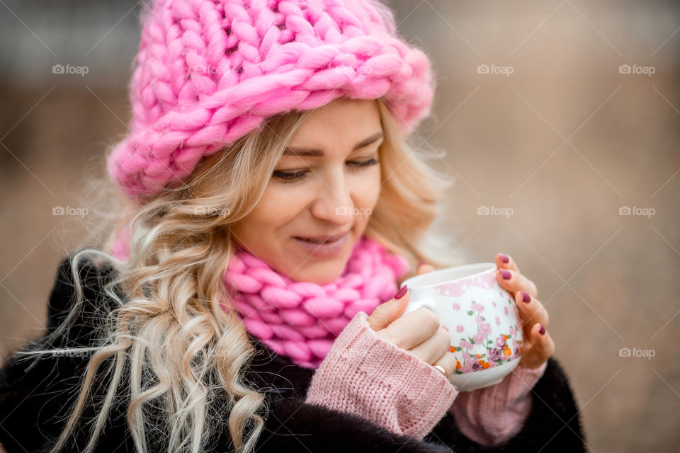 Outdoor Portrait of blonde woman in pink crochet accessories 