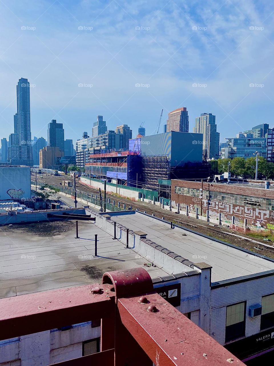 This is the view off the „Pulaski Bridge“ at „Newtown Creek“ in Queens overlooking adjacent buildings and the MTA train tracks as well as the combined LIC and „Manhattan“ skyline. 2023. Hypnotic Productions