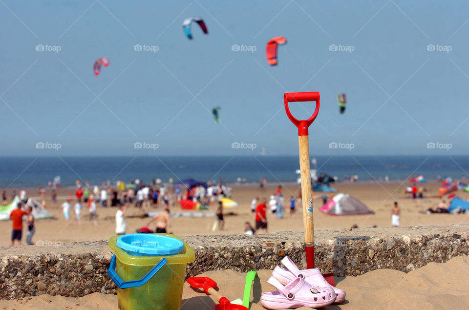 Buckets and spades and children's sandals in sharp focus in the