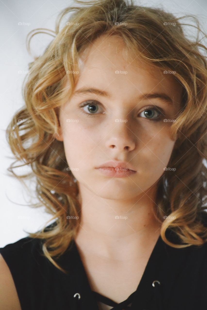 Girl with serious face in curly hair