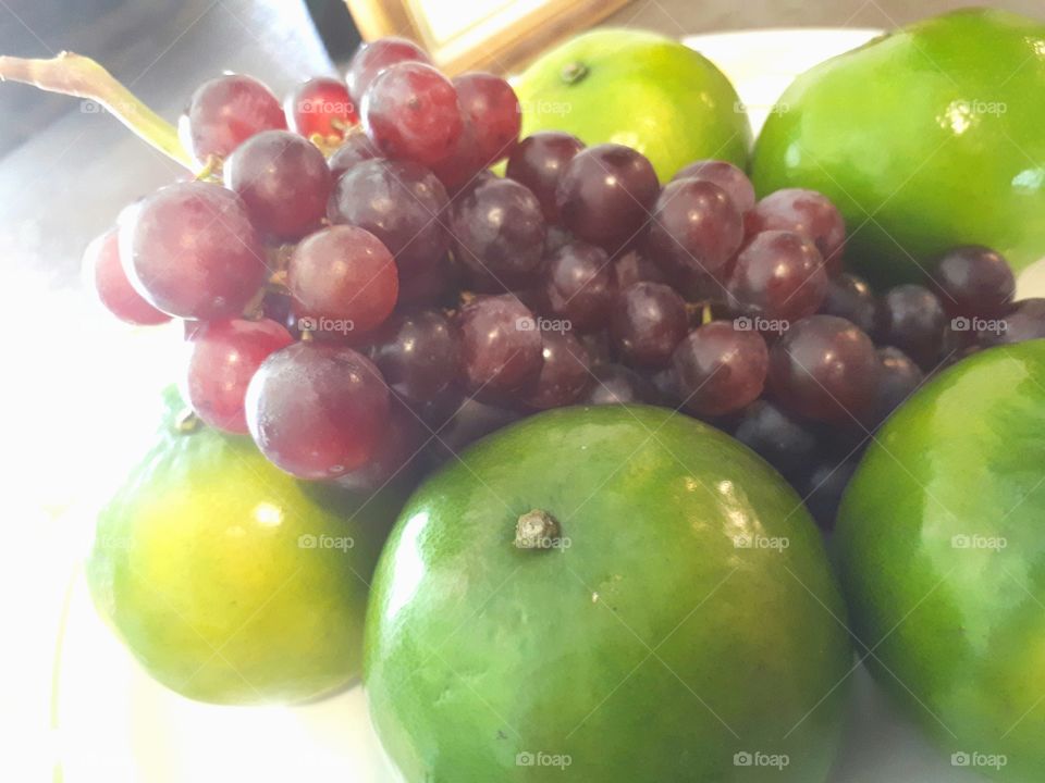 Grapes on green oranges