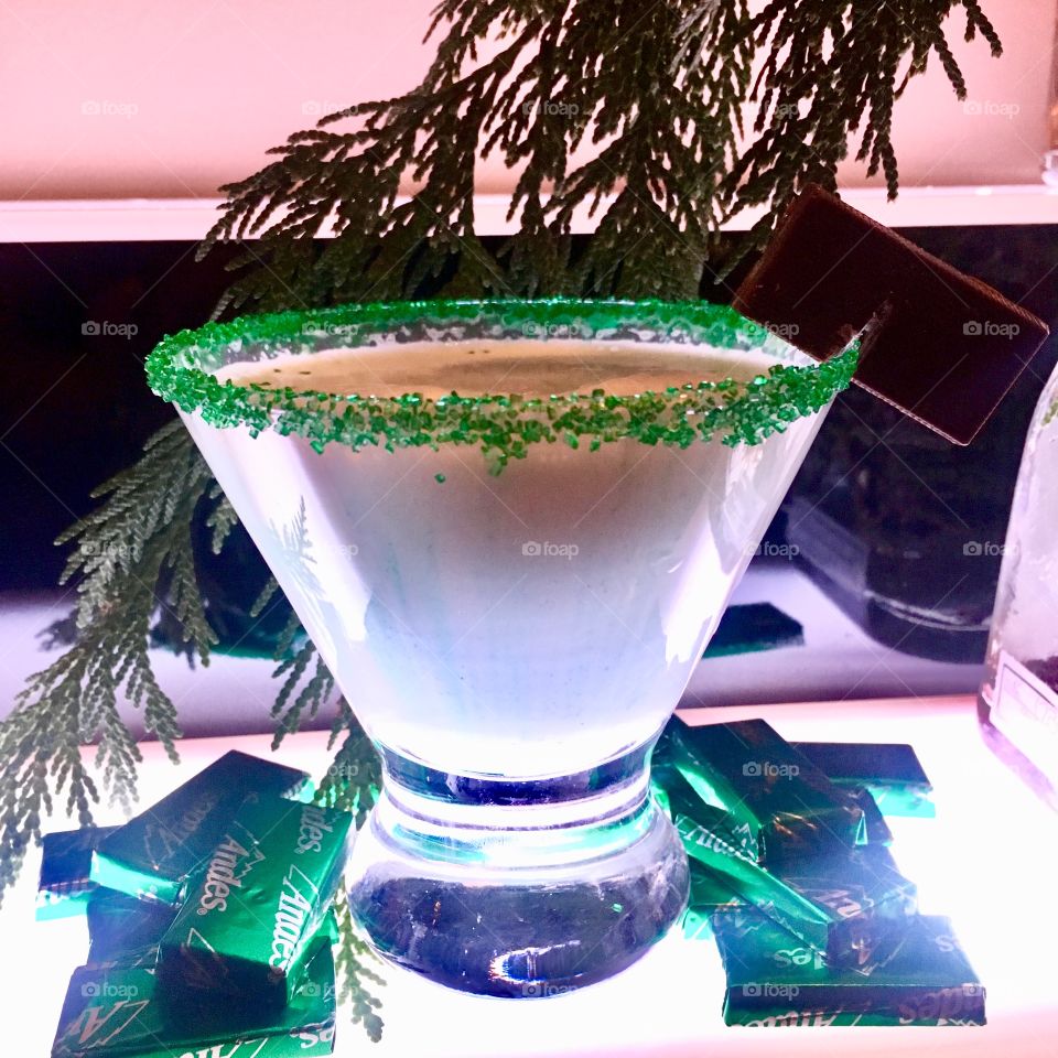 A minty, Andes candies flavored, white martini with green sugar on the rim.