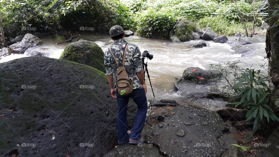 photographer taking long exposure shot of river