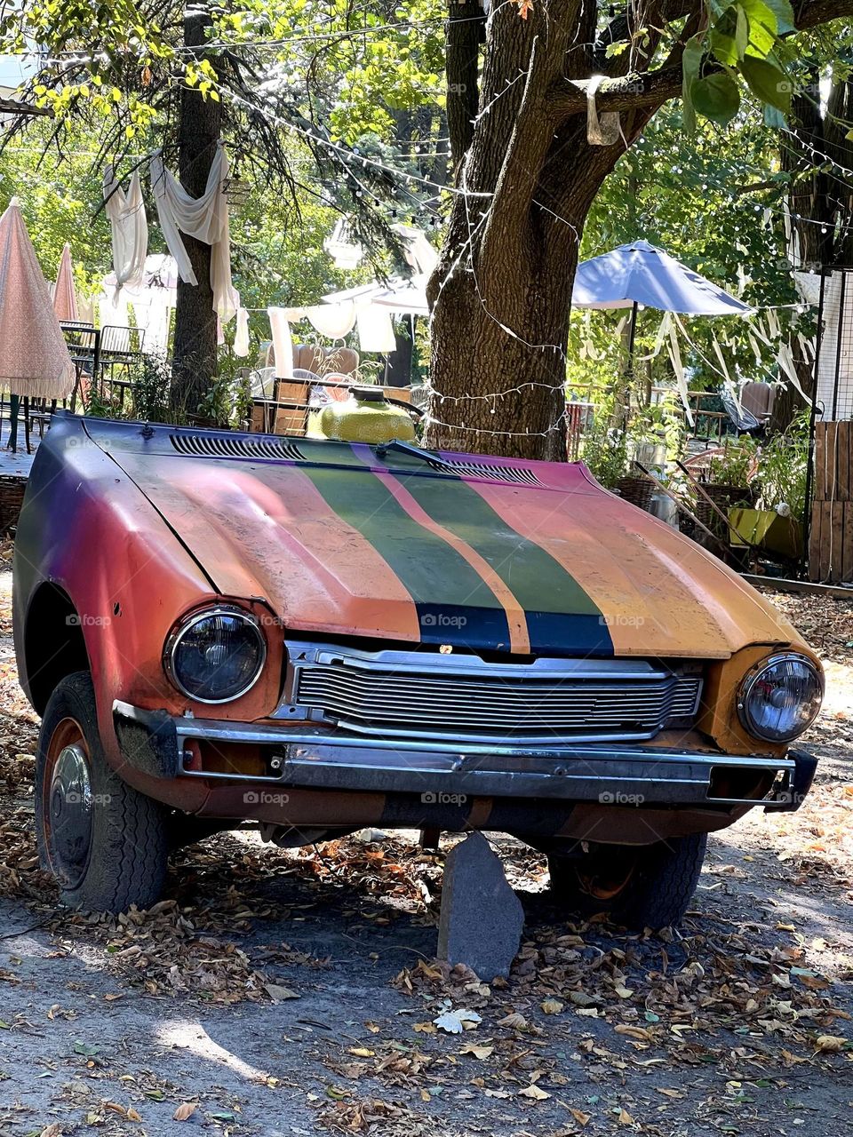 Half of the car on two wheels is parked in the park