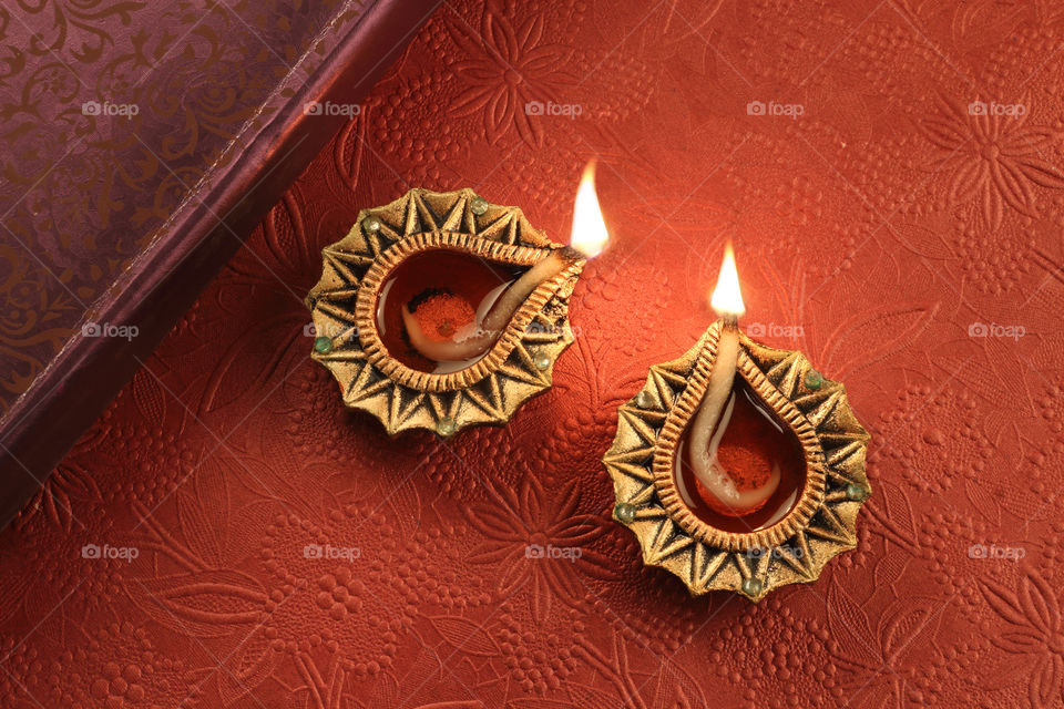 Indian festival Diwali diya oil lamp on red background