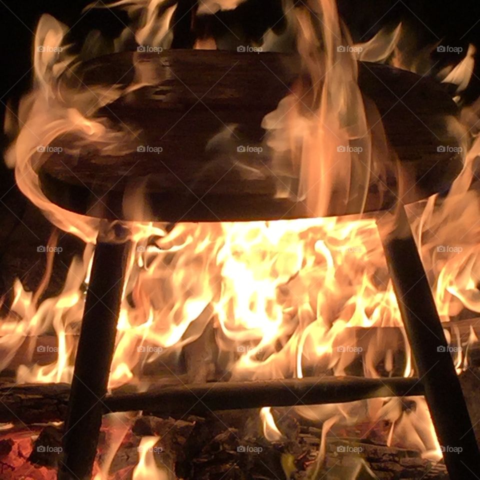 Charred chair in the middle of the fire pit in Maine, during October.