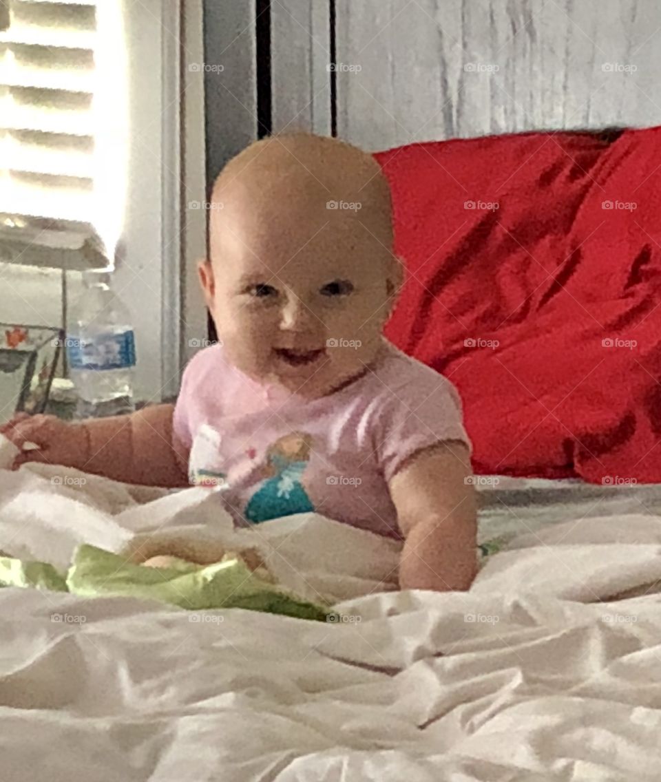 Freshly awakened from an early afternoon nap, beautiful grand-baby greets the rest of the day with a happy smile. 