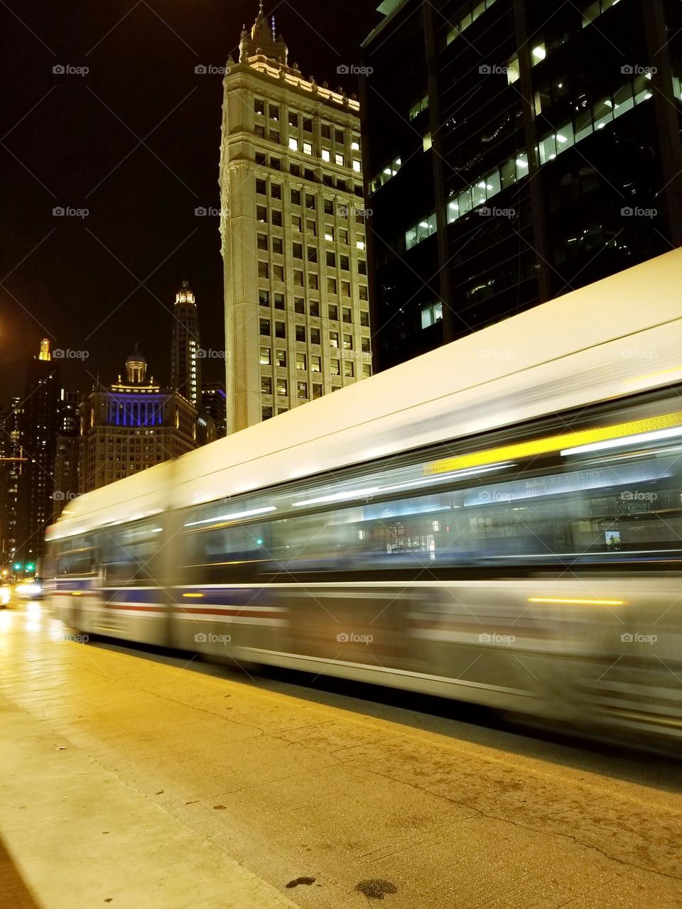 A city bus zooms down a city street in a time-lapse photo depicting modern urban living