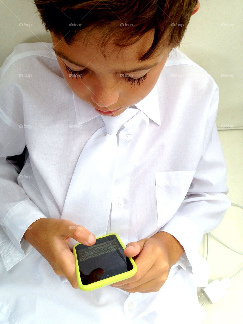 Boy with shirt and tie using mobile phone