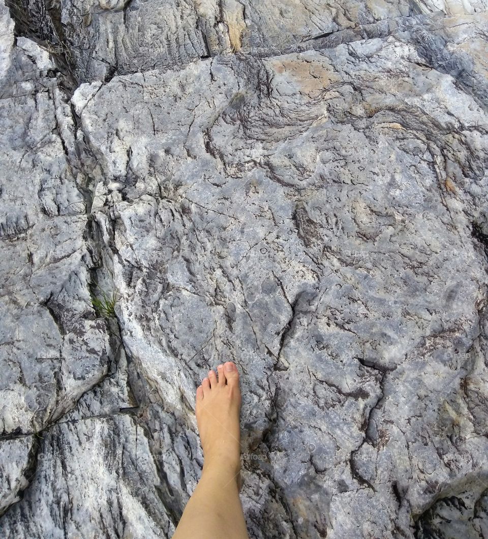Walking barefoot in a waterfall rock surface