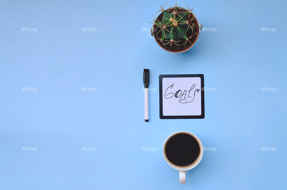 Business working morning with cup of hot coffee, pen, notebook on blue background close up. Top view, copy space, flat lay, mockup.